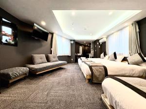 a hotel room with four beds and a couch at Oji正和ビル in Tokyo