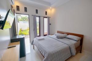 a bedroom with a bed and a large window at ARGA SHANKARA House in Sempidi +25 photos