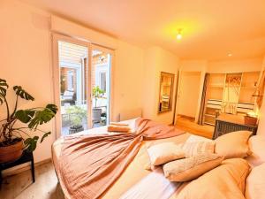 un grande letto in una stanza con una grande finestra di Maison Langevin 2-Bedroom House with Cozy Garden & Patio a Lille
