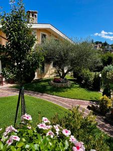 a garden with pink flowers in front of a house at Peperosa in collina B&B in Pescara