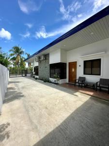 a patio of a house with a blue roof at Fully Airconditioned 2 Bedroom Unit Panglao Island in Dauis +5 photos