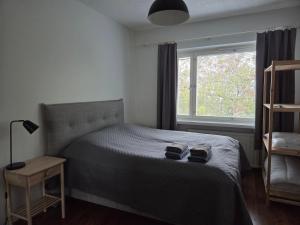 a bedroom with a bed with two slippers on it at Kaksio Kimpisessä in Lappeenranta