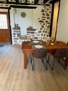 a dining room with a wooden table and chairs at La maison du Chateau in Mur-de-Barrez