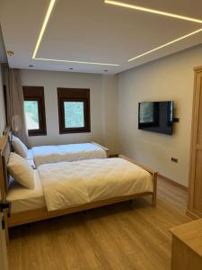 a bedroom with two beds and a flat screen tv at بيوت رفال Refal Homes in Ardeşen