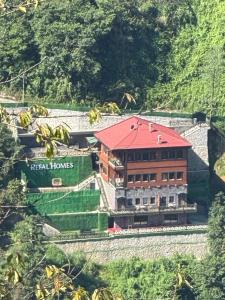 a building with a red roof on a mountain at بيوت رفال Refal Homes in Ardeşen