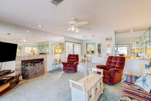 a living room with two chairs and a tv at Lakefront Townhouse with Lake, Pool & Tennis in Red Oak