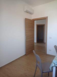 - un salon avec une table, des chaises et une porte dans l'établissement Tra cielo e mare, à Fiumicino