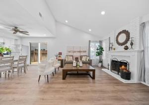 un soggiorno con mobili bianchi e un camino di #Marbella Lane - Modern Home with Private Backyard a Fullerton Altre 25 foto