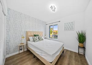 una camera da letto bianca con un letto e una finestra di #Marbella Lane - Modern Home with Private Backyard a Fullerton