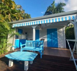 a blue bench on the deck of a house at Bungalow Carambole - Bleu des Iles vue mer in Deshaies