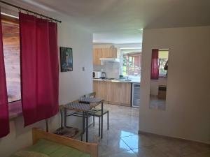 a kitchen with red curtains and a table and chairs at Domki u Ani in Okuninka
