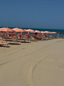 a group of tables and umbrellas on a beach at Villa Anna Francavilla al Mare in Francavilla al Mare