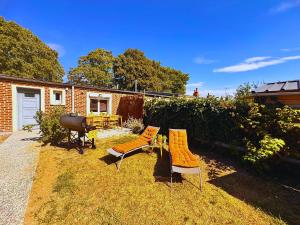 un cortile con due sedie, un tavolo e una griglia di Maison Langevin 2-Bedroom House with Cozy Garden & Patio a Lille