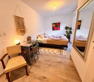 una camera da letto con un letto, un tavolo e uno specchio di Maison Langevin 2-Bedroom House with Cozy Garden & Patio a Lille