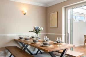 une salle à manger avec une table en bois et des fleurs. dans l'établissement Large House New Haven - East Sussex - Sleeps up to 10 guest - Parking - WiFi - Garden - Contractors - Families - Discounts for Long Term Bookings!, à Newhaven