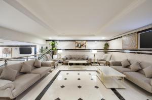 a living room with couches and a tv at Emaar Taiba Hotel in Al Madinah