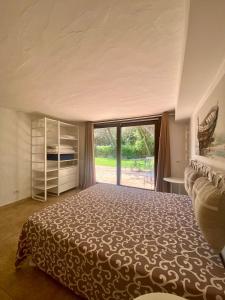 una camera da letto con un letto grande e una grande finestra di Villa Meigama - Porto Giunco a Notteri Altre 65 foto