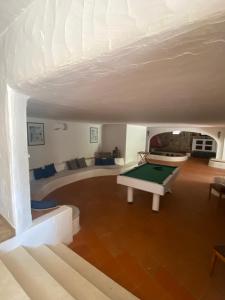 un soggiorno con tavolo da biliardo al centro di Villa Meigama - Porto Giunco a Notteri