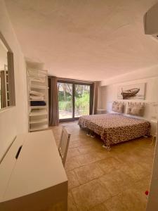 una camera da letto con un letto, un tavolo e una finestra di Villa Meigama - Porto Giunco a Notteri