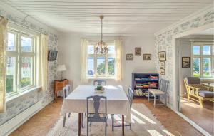 Holmedalにある6 Bedroom Lovely Home In Holmedalのテーブルと椅子と窓のあるダイニングルーム