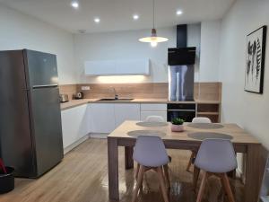 a kitchen with a table and chairs and a refrigerator at la violette in Aimargues