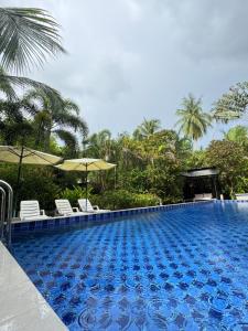 a large swimming pool with chairs and umbrellas at The Leaf Bankrut in Bang Saphan