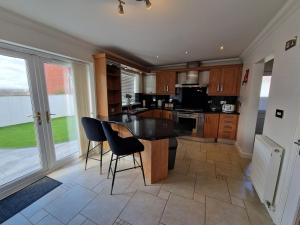 Una cocina con una mesa y sillas en una habitación. en Family Retreat, 6 bedrooms, sleeps 12 Near National Park And Bike Park Wales, en Pontsarn Station