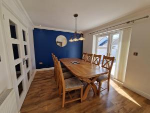Un comedor con mesa y sillas de madera. en Family Retreat, 6 bedrooms, sleeps 12 Near National Park And Bike Park Wales, en Pontsarn Station 23 fotos más