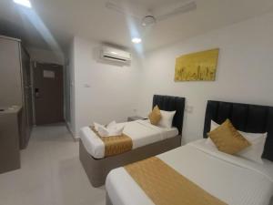 a hotel room with two beds in a room at La Riviera Suites in Hyderabad +46 photos