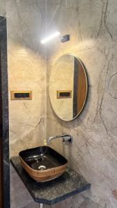 a bathroom with a wooden sink and a mirror at 4BHK Cozy Villa with Pvt Pool in Panchgani