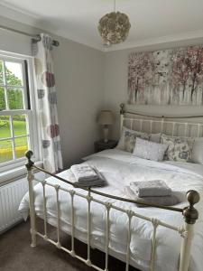 a bedroom with a white bed and a window at Garden cottage at The Glebe in Bayton