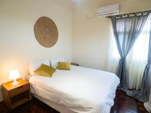a bedroom with a white bed and a window at Patri House in Maputo