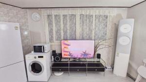 a living room with a television and a microwave at Seodamjae - Cozy 2 Bedroom Seodaemun Station Sleeps 6 in Seoul +7 photos