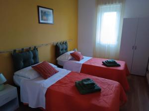 a bedroom with two beds with red and white sheets at Casa vacanze Sicilia in Casteltermini