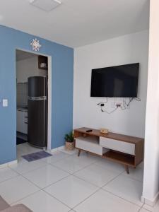 a living room with a flat screen tv on a wall at Casa aconchegante em Parnaíba in Parnaíba