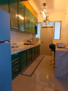 une cuisine avec des placards verts et un comptoir dans l'établissement Sakura Putrajaya Homestay Mus lim Only, à Putrajaya