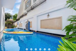 une grande piscine avec planche aogie dans un bâtiment dans l'établissement Villa Hồ Bơi Trần Văn Thời khu Du Lịch Tháp Tam Thắng, à Vung Tau