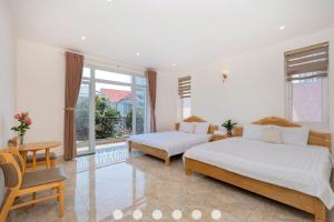 une chambre avec deux lits et une fenêtre dans l'établissement Villa Hồ Bơi Trần Văn Thời khu Du Lịch Tháp Tam Thắng, à Vung Tau 21 autres photos