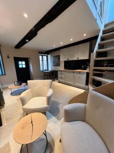una gran sala de estar con muebles blancos y una cocina. en La Lanterne B&B, en Heer