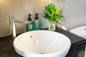 a white sink in a bathroom with a plant at The Silver Vinh Hoi Apartment in Ho Chi Minh City +20 photos