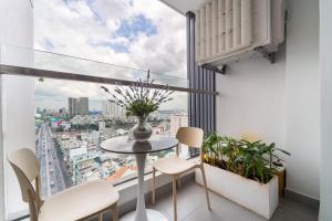 a room with a table and chairs and a large window at The Silver Vinh Hoi Apartment in Ho Chi Minh City