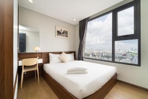 a bedroom with a large bed with a window at The Silver Vinh Hoi Apartment in Ho Chi Minh City
