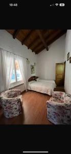 a bedroom with two beds and two chairs in it at Etxezurialde in Valcarlos