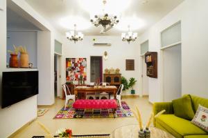a living room with a table and a green couch at Met Luxe Galleria in Jaipur