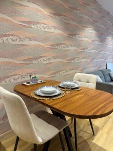 a wooden table with plates and glasses on top at Le Col Getaway Virage 1 in Le Bourg-dʼOisans