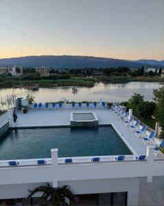 a swimming pool with lounge chairs and a body of water at Lantana in Ulcinj