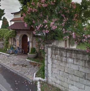 a building with a brick wall with pink flowers at Drini river view in Shkodër