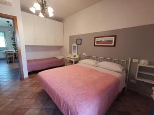 a bedroom with a large bed with a pink blanket at Villa Lucia B&B in Tortoreto Lido
