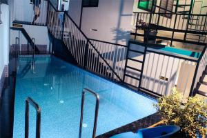 a large swimming pool with a stairway leading to a building at VGK Residency in Wayanad