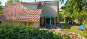 a house with a table and chairs in a yard at Le refuge barbezien in Lombez
